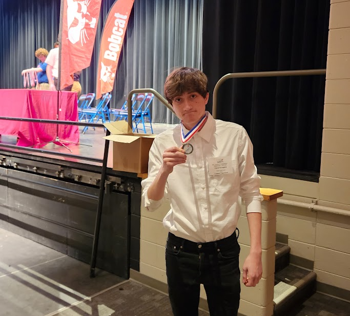 Trevor shows off his silver medal in the photography competition!