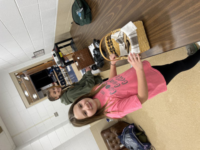 Students standing by baskets on tables