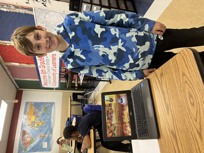 Boys showing off presentation on a laptop