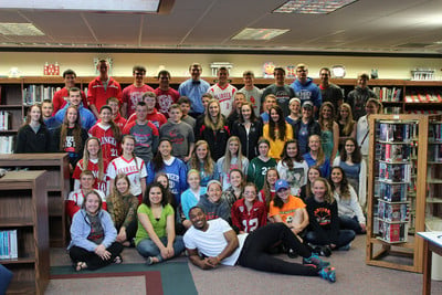 Group photo of Slinger FCA students in the library with former Packer